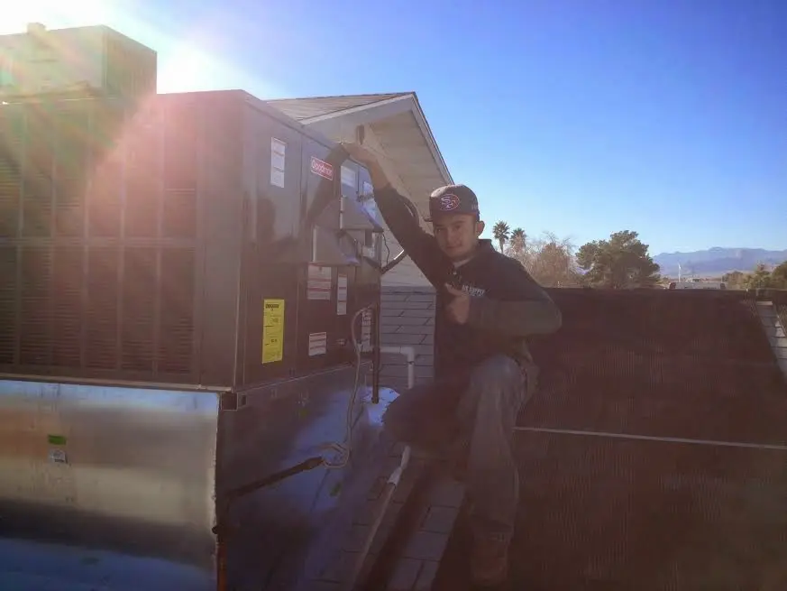 HVAC technician performing Boiler Repair on a rooftop unit in Babylon